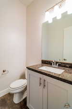 Bathroom with vanity, wood-type flooring, and toilet