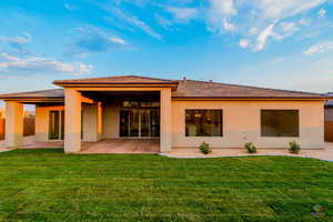 Rear view of house with a yard and a patio area