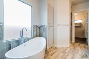 Bathroom with a bathing tub, sink, and tile walls