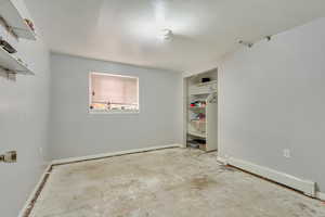 Unfurnished room with a baseboard heating unit and concrete floors