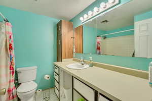 Bathroom with vanity, tile patterned floors, toilet, and walk in shower