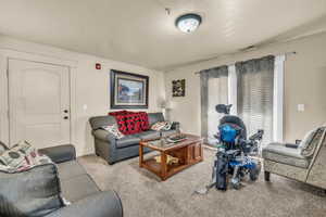 Carpeted living room featuring a textured ceiling