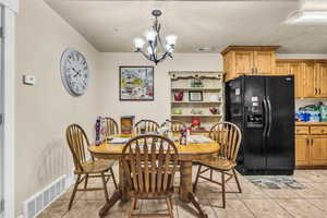 Tiled dining room with a chandelier