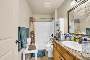 Full bathroom featuring shower / tub combo with curtain, vanity, tile patterned floors, and toilet