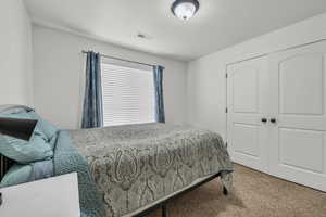 Carpeted bedroom with a closet