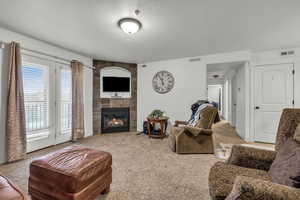 Carpeted living room with a large fireplace