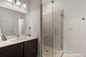 Bathroom featuring vanity and a shower with shower door