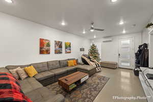 Living room with ceiling fan and a wall mounted AC