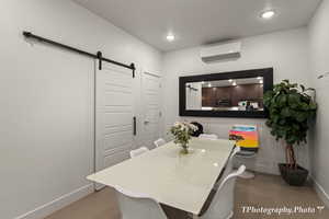 Tiled dining room with a wall mounted air conditioner and a barn door