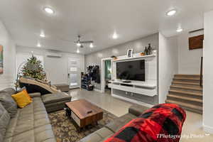 Living room featuring ceiling fan and a wall mounted AC