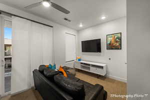 Carpeted living room featuring ceiling fan