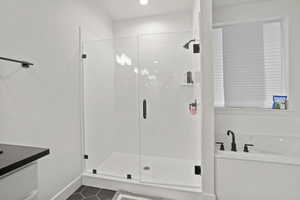Bathroom featuring tile patterned floors, separate shower and tub, and vanity