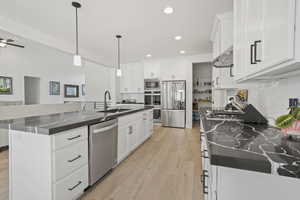 Kitchen with white cabinets, stainless steel appliances, sink, and a spacious island
