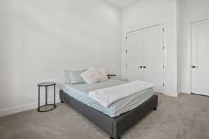 Bedroom with light colored carpet and a closet