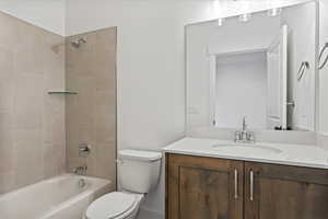 Full bathroom featuring tiled shower / bath, vanity, and toilet