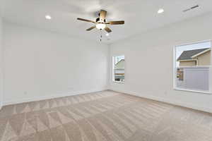 Empty room with light colored carpet and ceiling fan. Primary Bedroom