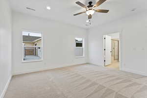 Carpeted spare room with ceiling fan