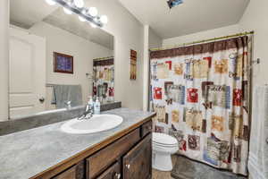 Bathroom with tile patterned flooring, vanity, curtained shower, and toilet