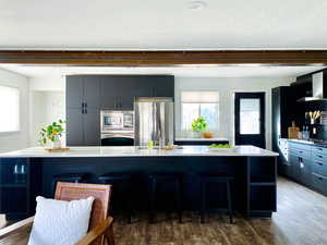 Kitchen featuring appliances with stainless steel finishes, a large island, and a breakfast bar area.