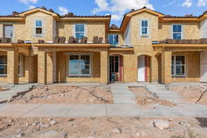 View of front of property with a porch, a tiled roof, and stucco siding