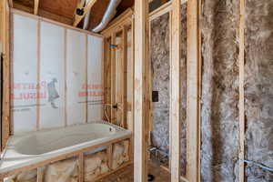 Full bath featuring a relaxing tiled tub