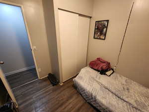 Bedroom featuring a closet and dark hardwood / wood-style floors