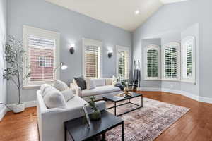 Living room with lofted ceiling and light wood-type flooring