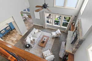 Living room featuring a high ceiling, carpet, and ceiling fan