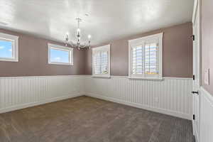 Carpeted bedroom with a textured ceiling and a notable chandelier