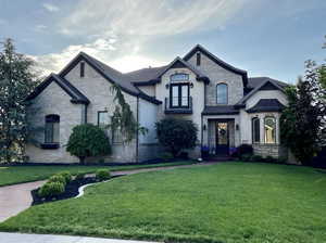 French provincial home with a front yard