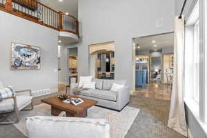 Living room with a towering ceiling and light hardwood / wood-style floors