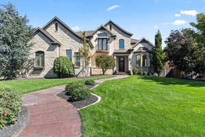 French country inspired facade with a front yard