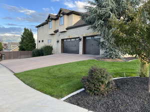 View of front of house with a garage and a front yard