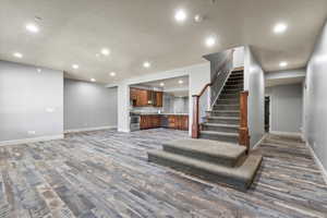 Recreation living room with dark hardwood / wood-style floors