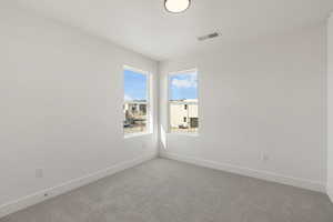 Spare room featuring carpet floors and baseboards