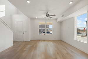 Empty room featuring light wood finished floors, ceiling fan, and recessed lighting