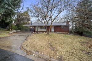 Single story home with a carport and a front yard