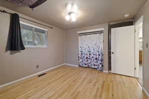 Unfurnished bedroom featuring light hardwood / wood-style flooring and a textured ceiling