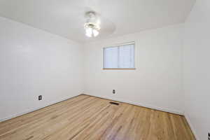 Spare room with ceiling fan and light wood-type flooring