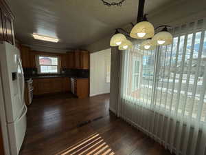 Kitchen featuring sink, tasteful backsplash, a textured ceiling, dark hardwood / wood-style floors, and white appliances