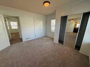 Unfurnished bedroom featuring multiple windows and carpet flooring