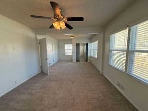 Spare room featuring light carpet and a textured ceiling