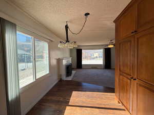 Hall with dark hardwood / wood-style floors, a chandelier, and a textured ceiling