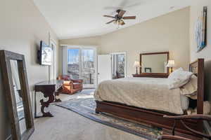 Carpeted bedroom featuring ceiling fan, access to exterior, and vaulted ceiling