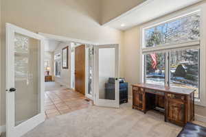 Bathroom featuring tile patterned flooring, vaulted ceiling, and french doors