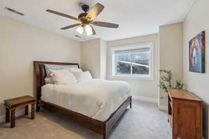 Carpeted bedroom with ceiling fan