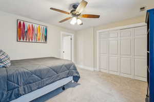 Bedroom featuring ceiling fan, carpet floors, and a closet