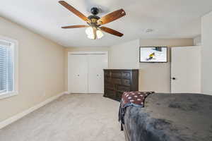 Bedroom featuring ceiling fan, light colored carpet, and a closet