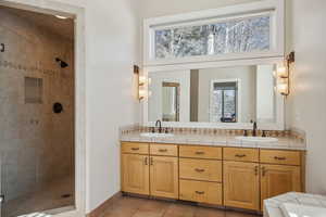 Bathroom featuring tile patterned flooring, vanity, and a shower with shower door