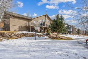 Snow covered property with a balcony